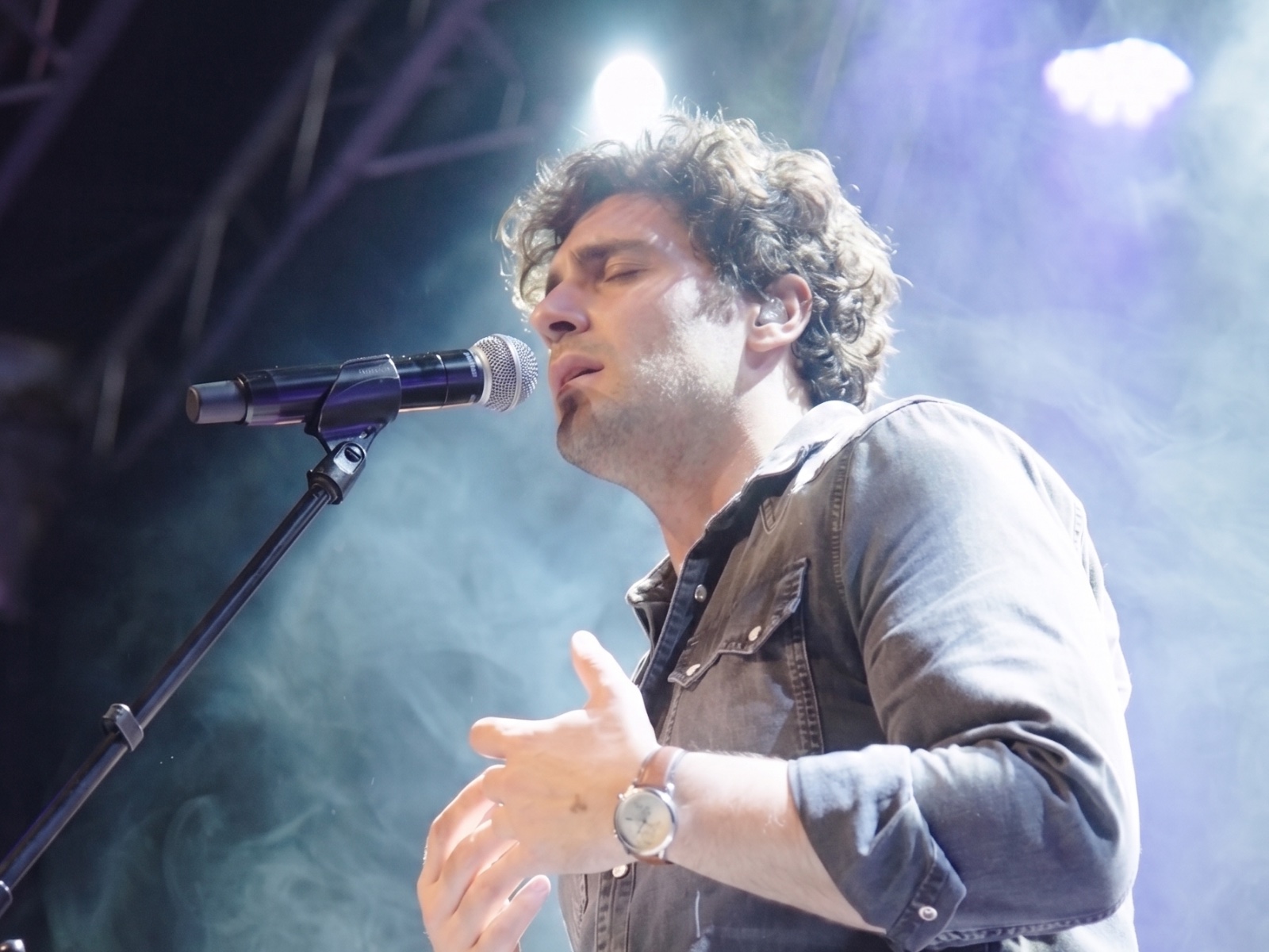 Chanteur au micro sur scène dans la fumée et les lumières